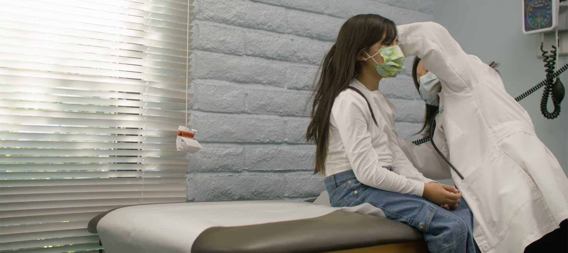 FQHC marketing agency Abra Marketing has produced many marketing videos for our FQHC clients. This photo is a screenshot from a video shoot for an FQHC in Orange County in Southern California. The image is of a provider checking the ears of a young girl patient in their pediatric department.